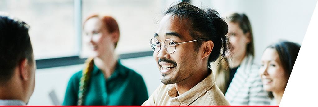 Man looking and smiling in meeting | CNA Insurance