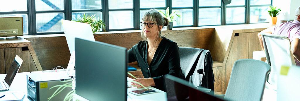 Woman working diligently on computer in office | CNA Insurance