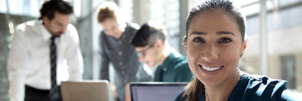 Woman smiling at camera in office l CNA Insurance