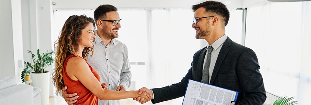 Male real estate agent shaking hands with couple closing a deal | CNA Insurance