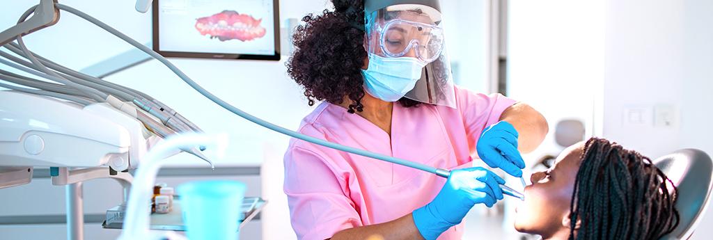 Female dental professional with young girl at dentist appointment | CNA Insurance