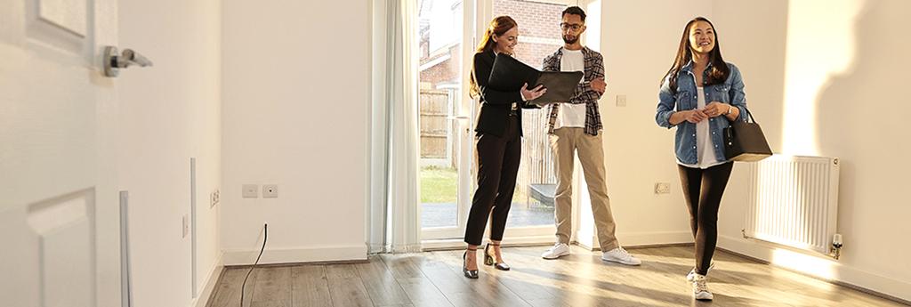 Female real estate agent showing new home brochure to couple | CNA Insurance