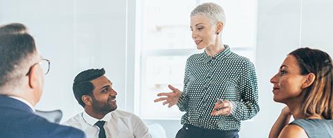 Female business executive leading diverse team meeting | CNA Insurance