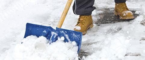 Man shoveling snow in front of business | CNA Insurance