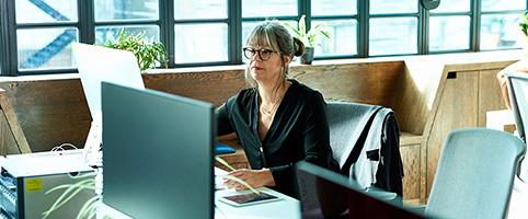 Woman working at computer in newsroom | CNA Insurance